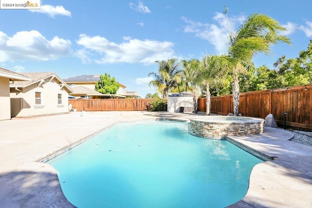 view of swimming pool featuring a patio area and an in ground hot tub