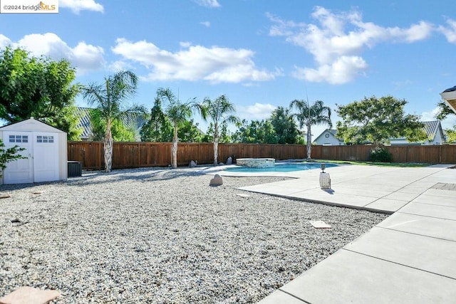 view of yard featuring a shed, a patio, and a fenced in pool