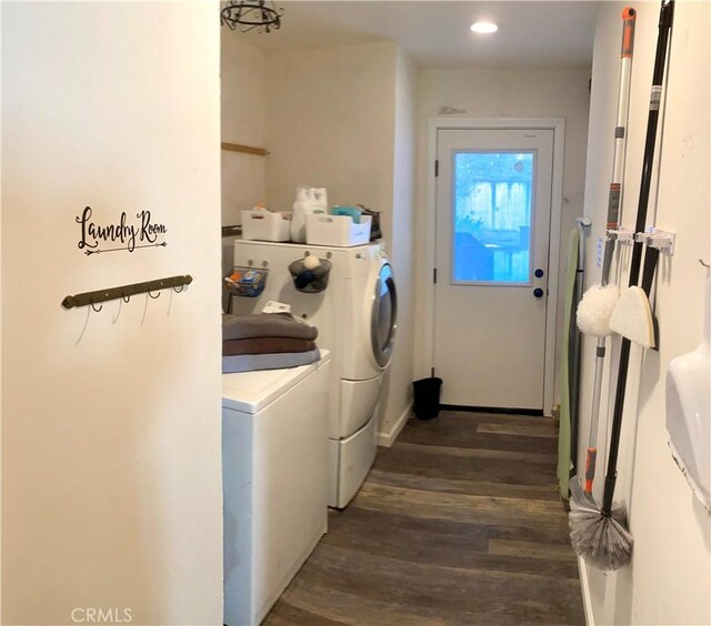 clothes washing area with dark hardwood / wood-style floors and washer and dryer