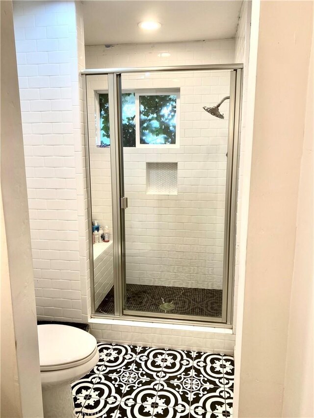 bathroom with tile patterned floors, toilet, and walk in shower