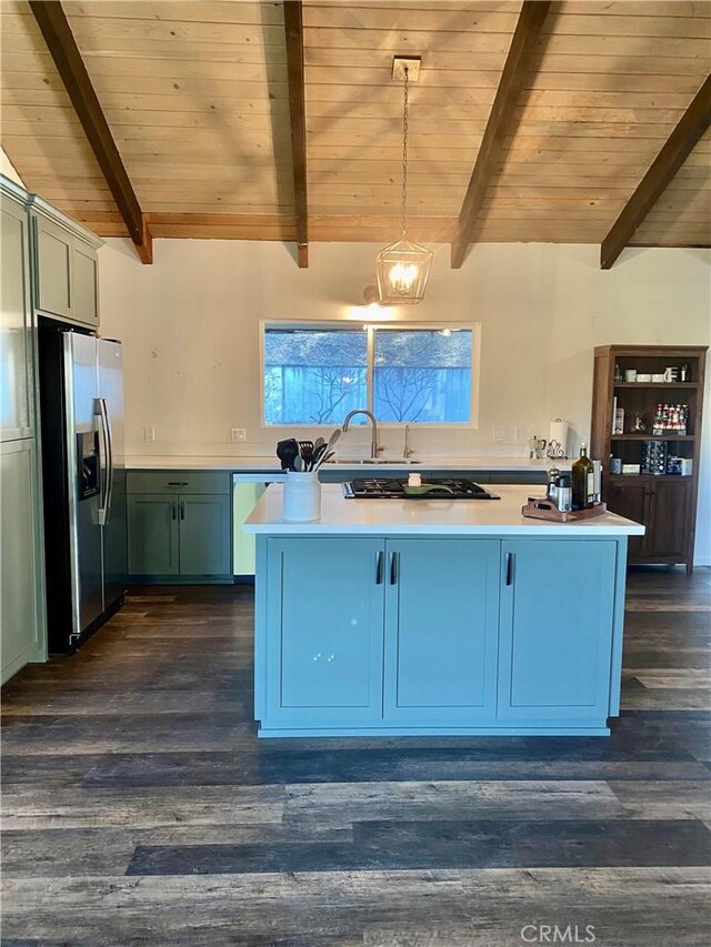 kitchen with decorative light fixtures, lofted ceiling with beams, wooden ceiling, stainless steel fridge, and black gas stovetop