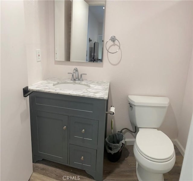 bathroom featuring vanity, hardwood / wood-style flooring, and toilet