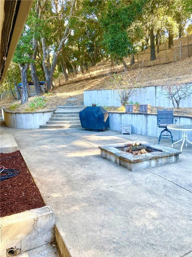 view of patio with an outdoor fire pit and a grill