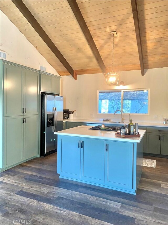 kitchen featuring vaulted ceiling with beams, decorative light fixtures, a center island, dark hardwood / wood-style flooring, and stainless steel appliances