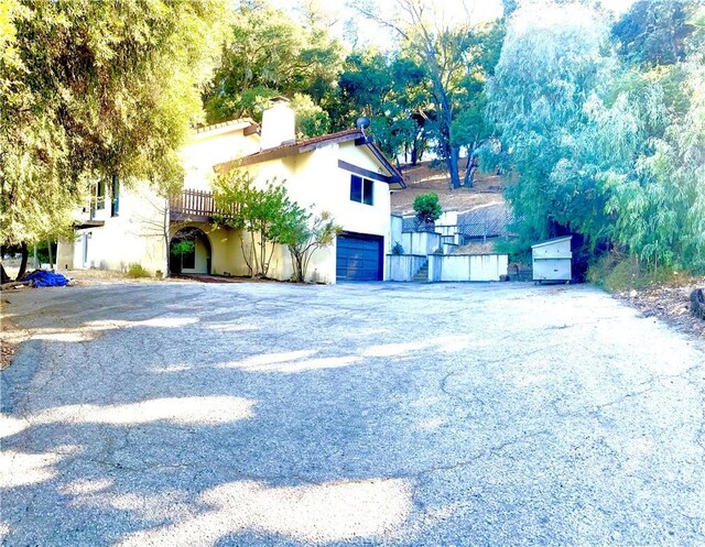 view of front facade with a wooden deck and a garage