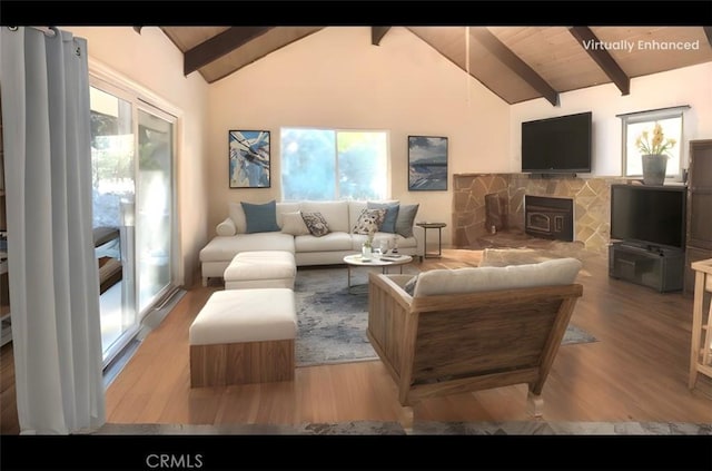 living room with plenty of natural light, beam ceiling, light hardwood / wood-style floors, and a wood stove