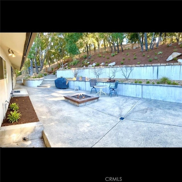 view of patio / terrace featuring an outdoor fire pit