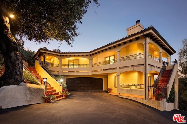 mediterranean / spanish-style house with a balcony and a garage