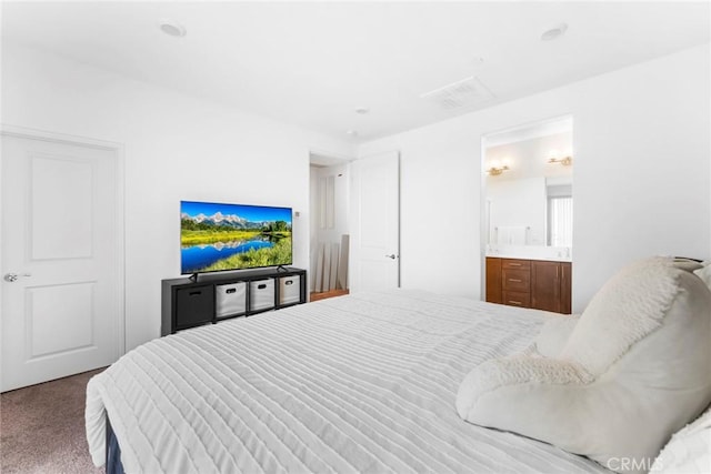 bedroom with carpet flooring and connected bathroom