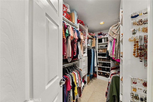 walk in closet with light tile patterned floors