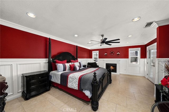 tiled bedroom with a textured ceiling, ceiling fan, and crown molding