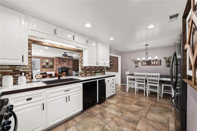 kitchen with white cabinets, decorative light fixtures, ceiling fan, and backsplash