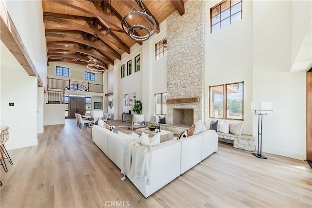 living room featuring beamed ceiling, wood ceiling, a fireplace, and high vaulted ceiling