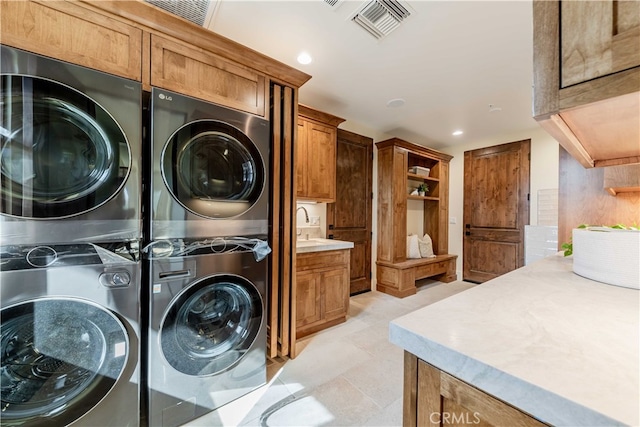 laundry room with cabinets and stacked washer and dryer