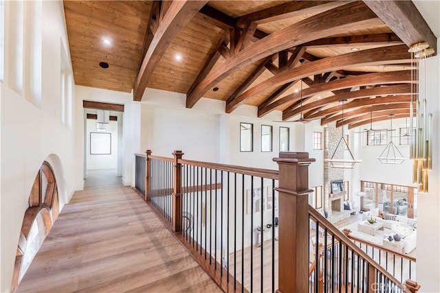 corridor with light wood-type flooring, wooden ceiling, and vaulted ceiling with beams