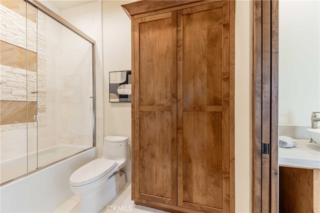 bathroom featuring toilet, bath / shower combo with glass door, and tile patterned floors