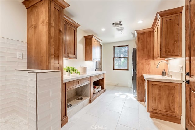 kitchen featuring stainless steel fridge, sink, and light tile patterned floors