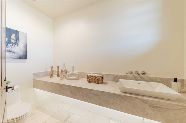 bathroom featuring toilet, sink, and tile patterned flooring