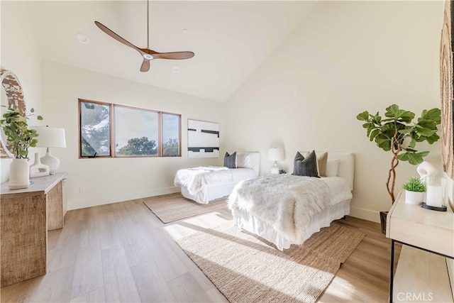 bedroom featuring ceiling fan, high vaulted ceiling, and light wood-type flooring