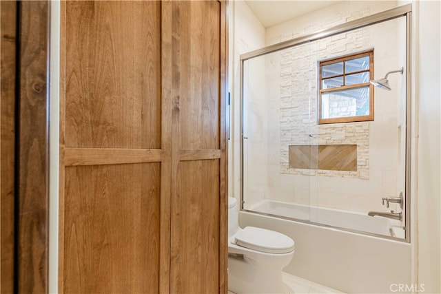 bathroom featuring toilet, enclosed tub / shower combo, and tile patterned flooring