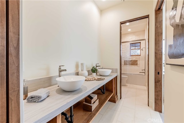 full bathroom with tiled shower / bath, vanity, toilet, and tile patterned flooring