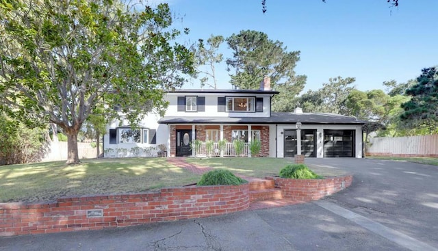 view of front of home with a porch, a front lawn, and a garage