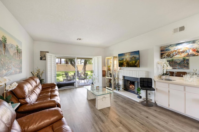 living room featuring bar and light hardwood / wood-style floors