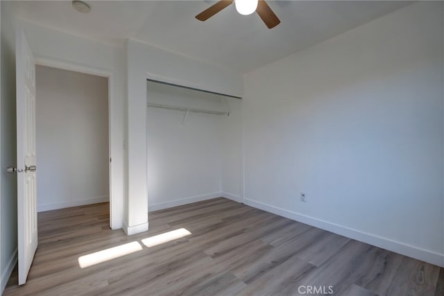 unfurnished bedroom featuring a closet, light hardwood / wood-style floors, and ceiling fan