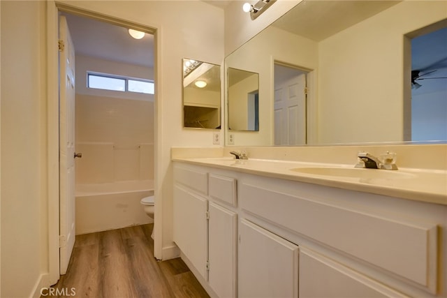 full bathroom featuring toilet, shower / washtub combination, hardwood / wood-style floors, vanity, and ceiling fan