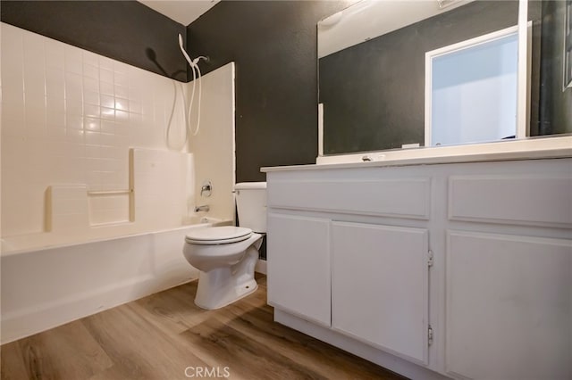 full bathroom featuring vanity, bathtub / shower combination, hardwood / wood-style floors, and toilet