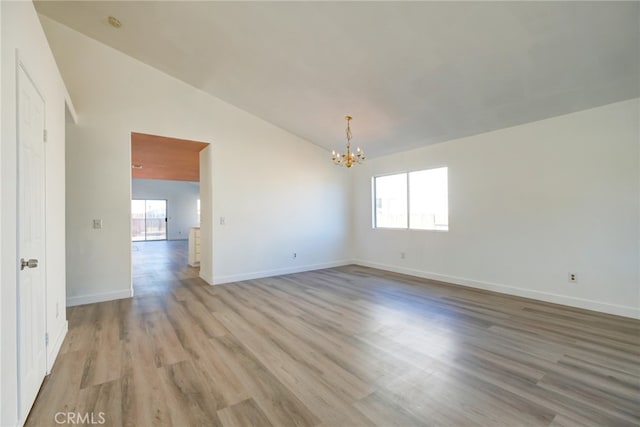 empty room with light hardwood / wood-style flooring, lofted ceiling, and a wealth of natural light