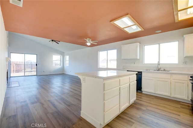 kitchen featuring a center island, sink, plenty of natural light, and vaulted ceiling