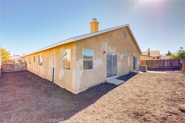 rear view of property with central AC