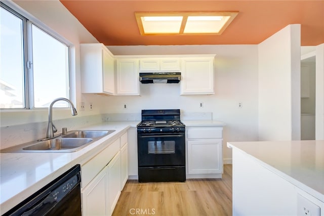 kitchen with a wealth of natural light, sink, black appliances, and light wood-type flooring