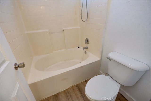 bathroom featuring toilet, hardwood / wood-style flooring, and bathing tub / shower combination