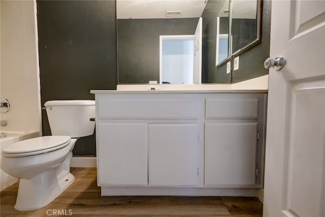 bathroom with vanity, toilet, hardwood / wood-style flooring, and a bath