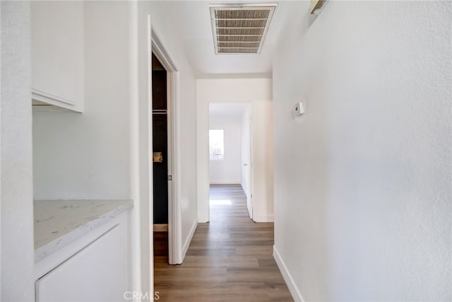 corridor with hardwood / wood-style flooring