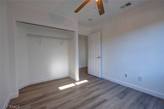 unfurnished bedroom with hardwood / wood-style flooring, a closet, and ceiling fan