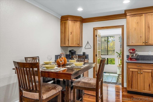 dining area with hardwood / wood-style floors and ornamental molding