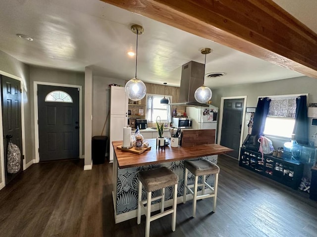 dining area with dark hardwood / wood-style floors, sink, and beam ceiling