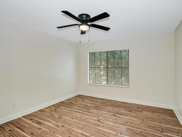 empty room with ceiling fan and light hardwood / wood-style flooring