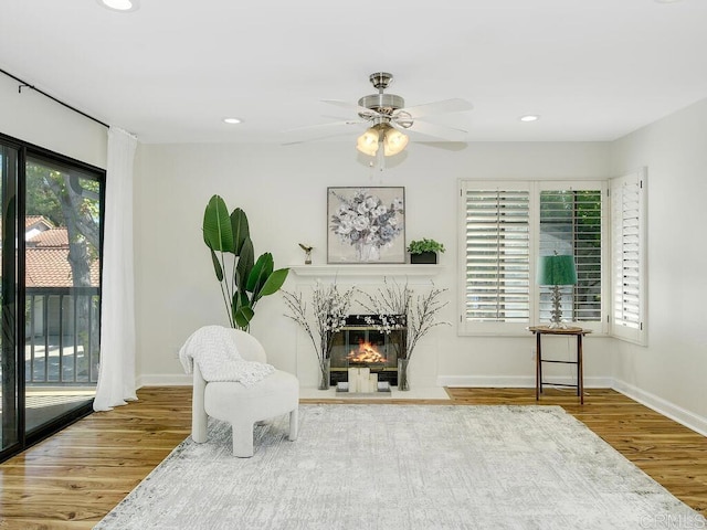 sitting room with ceiling fan and hardwood / wood-style flooring