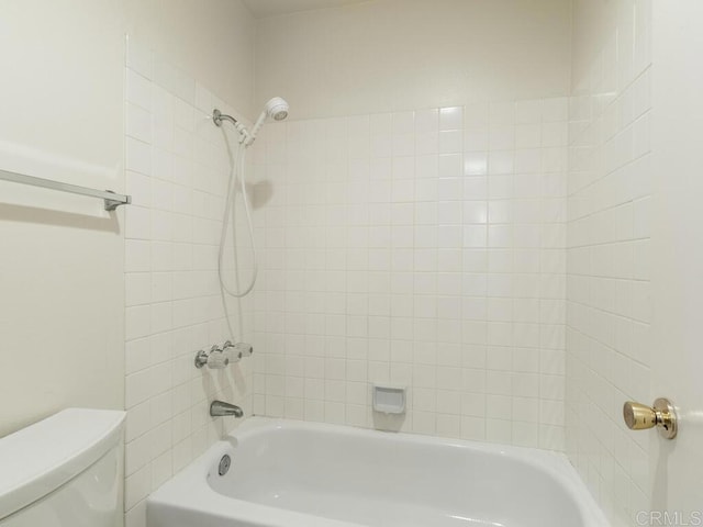 bathroom featuring toilet and tiled shower / bath