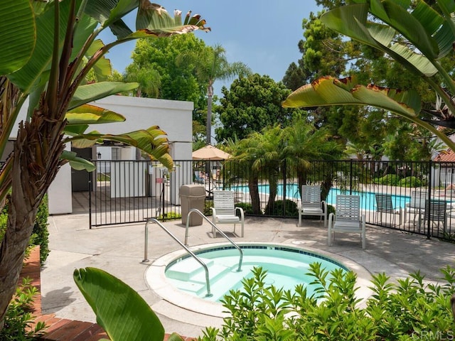 view of swimming pool featuring a patio area and a community hot tub