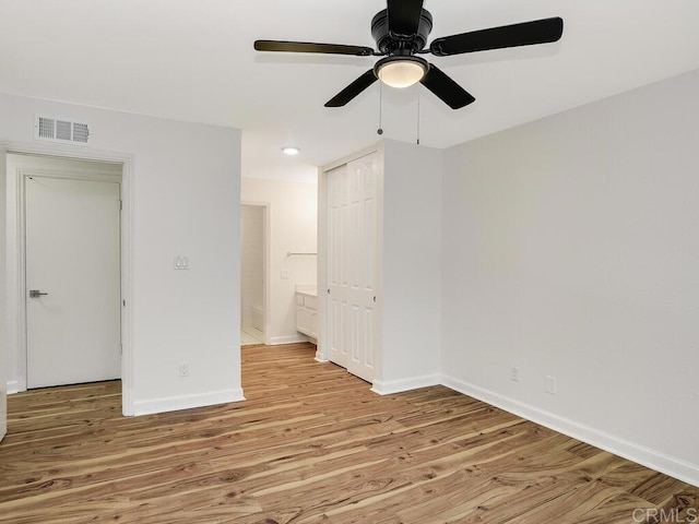 unfurnished bedroom with ensuite bath, light hardwood / wood-style flooring, and ceiling fan