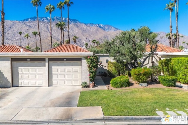 view of front of house with a mountain view, a garage, and a front yard