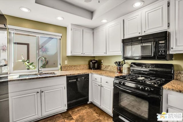 kitchen featuring light stone counters, sink, white cabinets, and black appliances