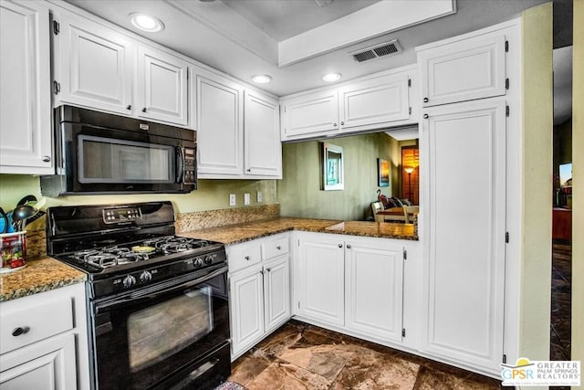 kitchen with black appliances, white cabinetry, and dark stone counters