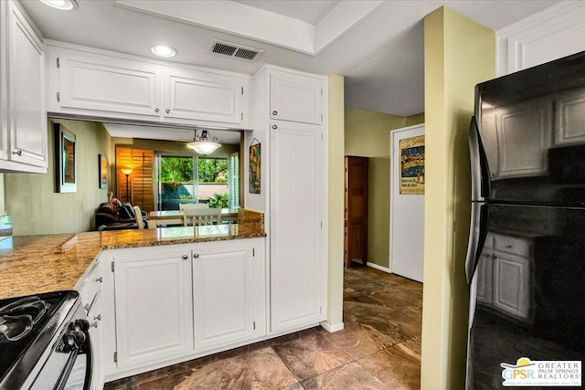 kitchen featuring black appliances, dark stone countertops, white cabinetry, and kitchen peninsula