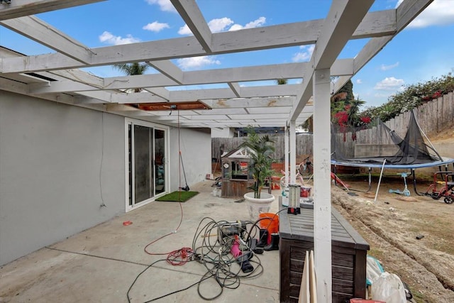 view of patio with a trampoline and a pergola